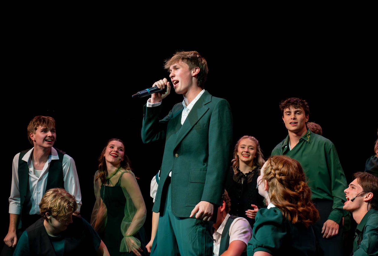 An Aspire Performing Co. soloist performs with the show choir behind