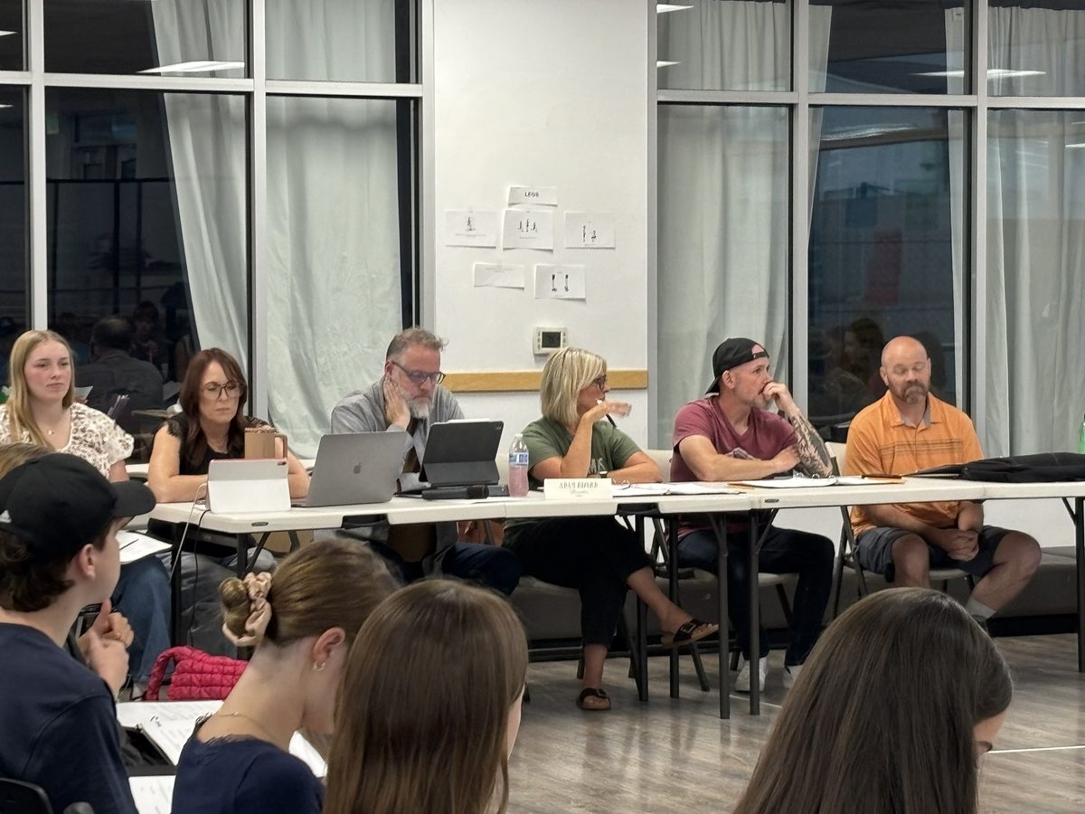 Encore’s creative team seated at the table during a read-through of A Christmas Carol