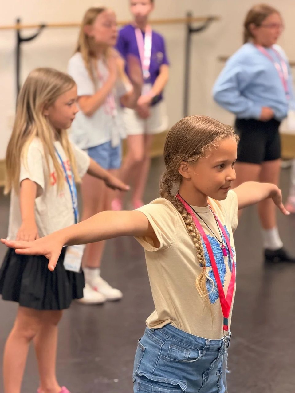 A Young Artist extends her arms during a dance rehearsal