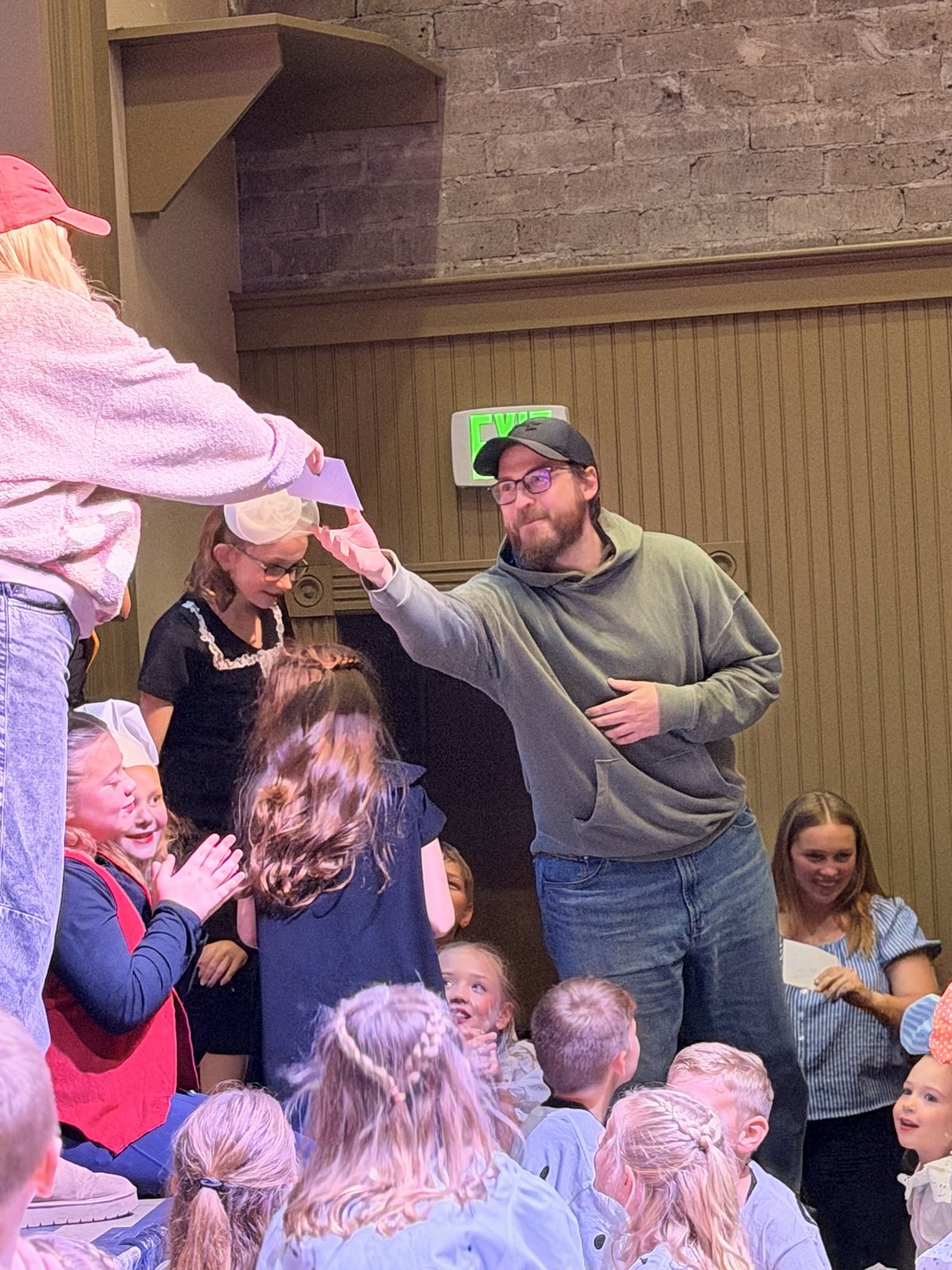 A member of the Encore team handing a note to a young performer during closing night