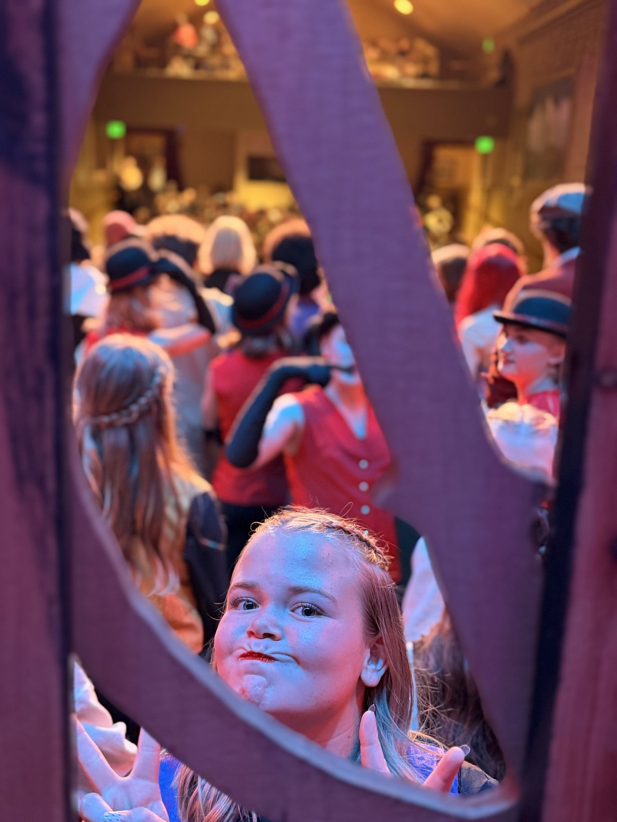 A Villains Night performer peeking through a set piece toward the audience
