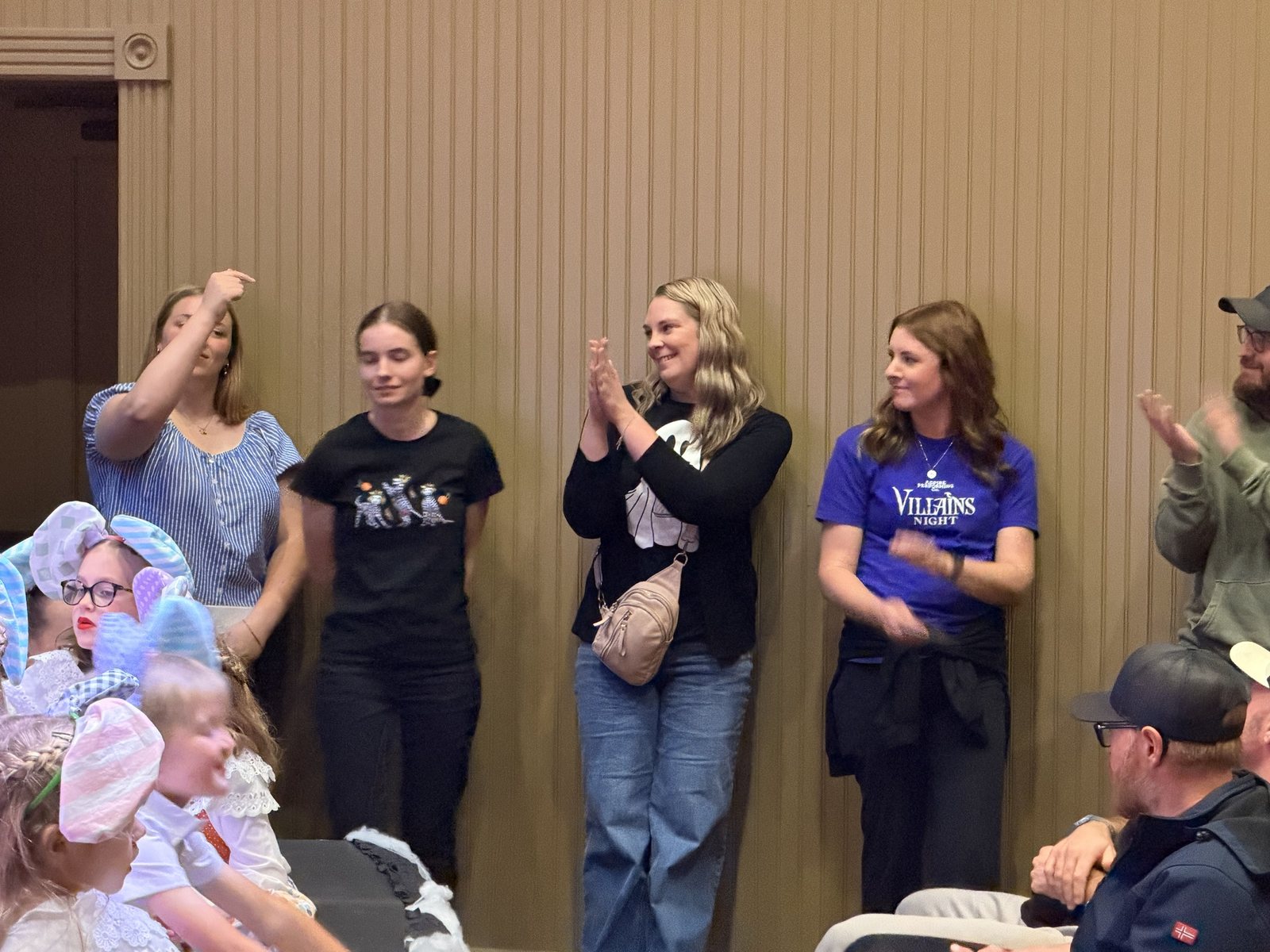 Members of the Encore team and ambassadors standing along the wall applauding the company