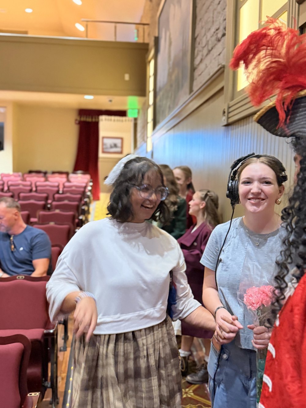 Two members of the Villains Night company in the house after the performance, one holding flowers