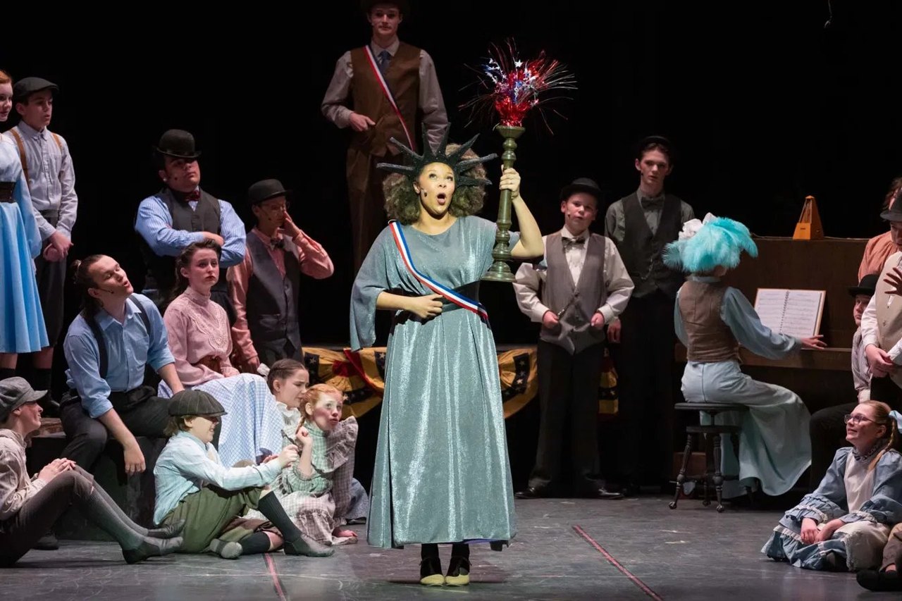 A patriotic celebration scene from Encore's The Music Man, featuring a Statue of Liberty costume