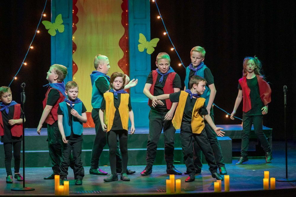 Young Artists in colorful vests performing a number at an Encore camp showcase
